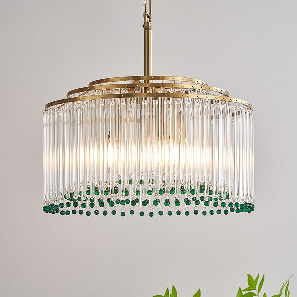 Close view of the clear glass rods and tiered gold rings of this Clérachic chandelier, with green beads at the bottom.