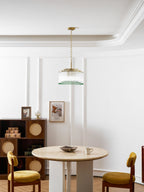 This Clérachic chandelier hangs high above a round dining table with mustard velvet chairs and a rattan-front cabinet.