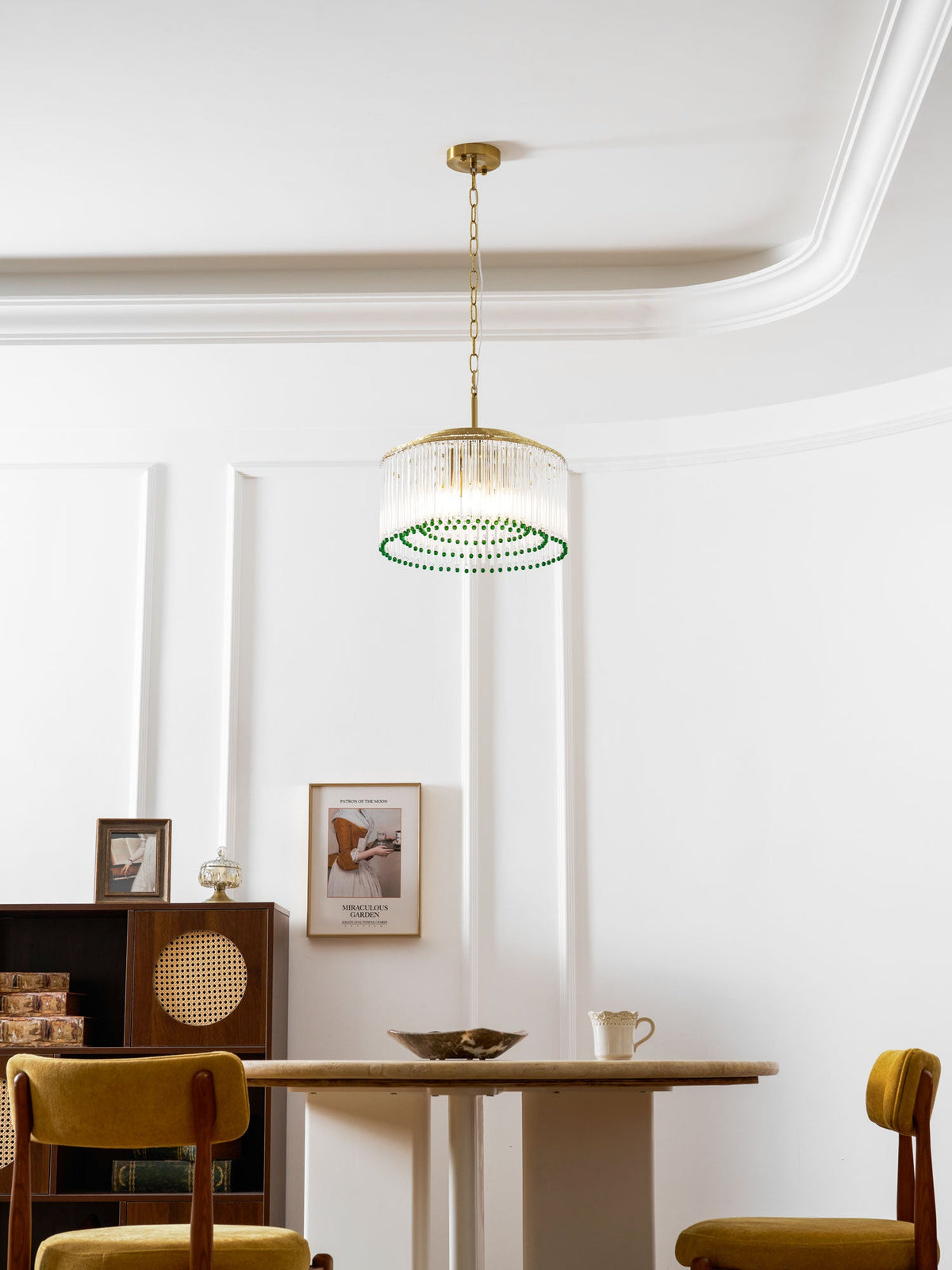 Hung low over a marble table, this Clérachic gold and glass chandelier shows its rings of green beads from below.