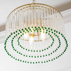 Looking up into this Clérachic chandelier, three rings of green beads hang below its candle bulbs and clear glass rods.