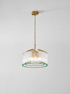 A Clérachic chandelier with candle-style bulbs inside a drum of glass rods, ringed with green beads, on a grey background.