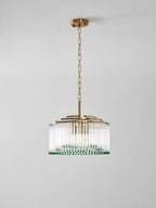 Side view of this Clérachic chandelier, with stepped gold rings above its clear glass rods, on a plain grey wall.