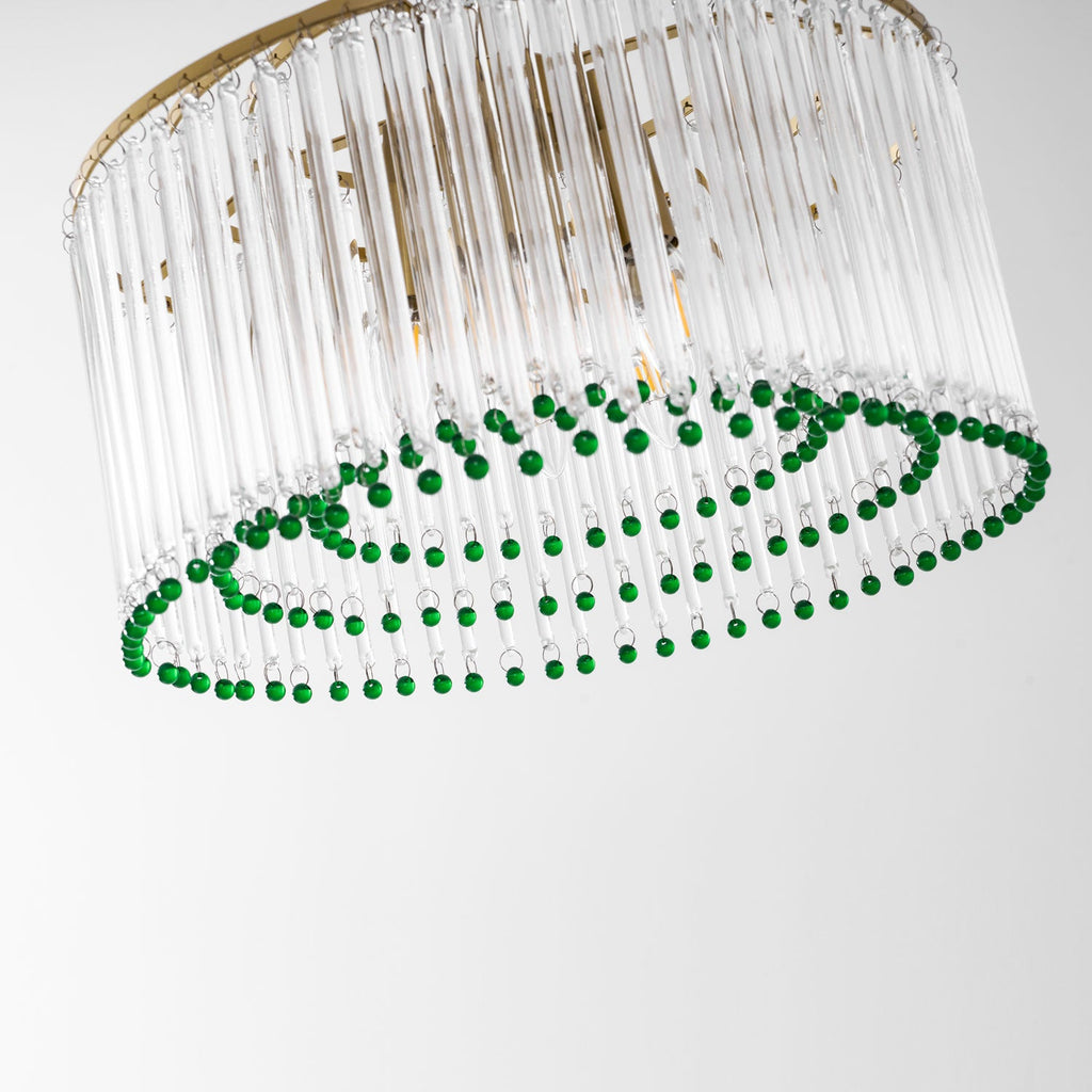 Tilted close view of the green bead rings beneath the clear glass rods of this Clérachic chandelier.