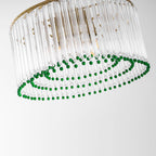 Tilted close view of the green bead rings beneath the clear glass rods of this Clérachic chandelier.