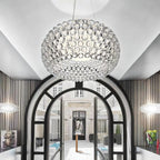 A large clear sphere pendant hangs in front of an arched black-framed doorway, with a smaller one at each side, from Clérachic.