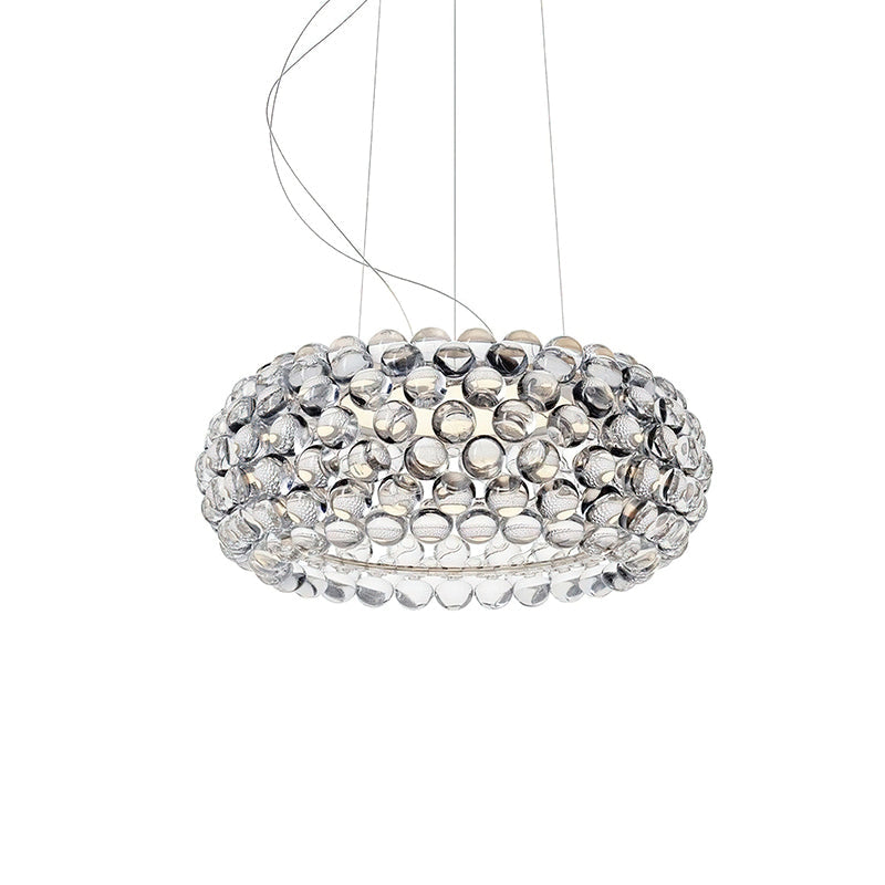A clear sphere pendant of medium size, unlit, hangs from fine cables against a white backdrop, from Clérachic.