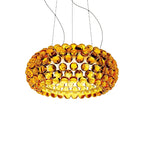 A gold-amber sphere pendant glows brightly on four fine cables against white, with a deeper orange on its outer spheres, from Clérachic.