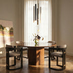 Clérachic cluster pendant light grouped in black, white and gold finishes above a round dining table by a sheer curtain.