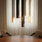 Clérachic cluster pendant light cluster in black, white and gold hanging low over a walnut dining table in daylight.