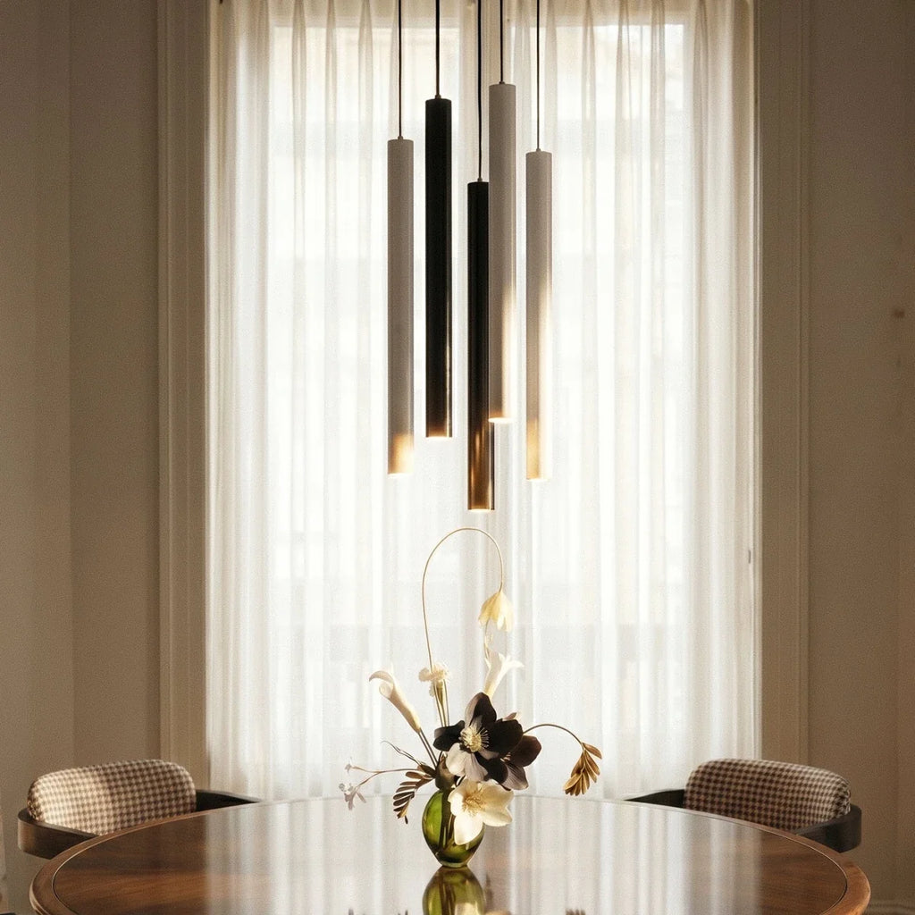 Clérachic cluster pendant light cluster in black, white and gold finishes lit above a table set with fresh flowers.