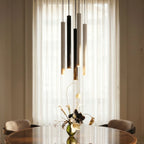 Clérachic cluster pendant light cluster in black, white and gold finishes lit above a table set with fresh flowers.