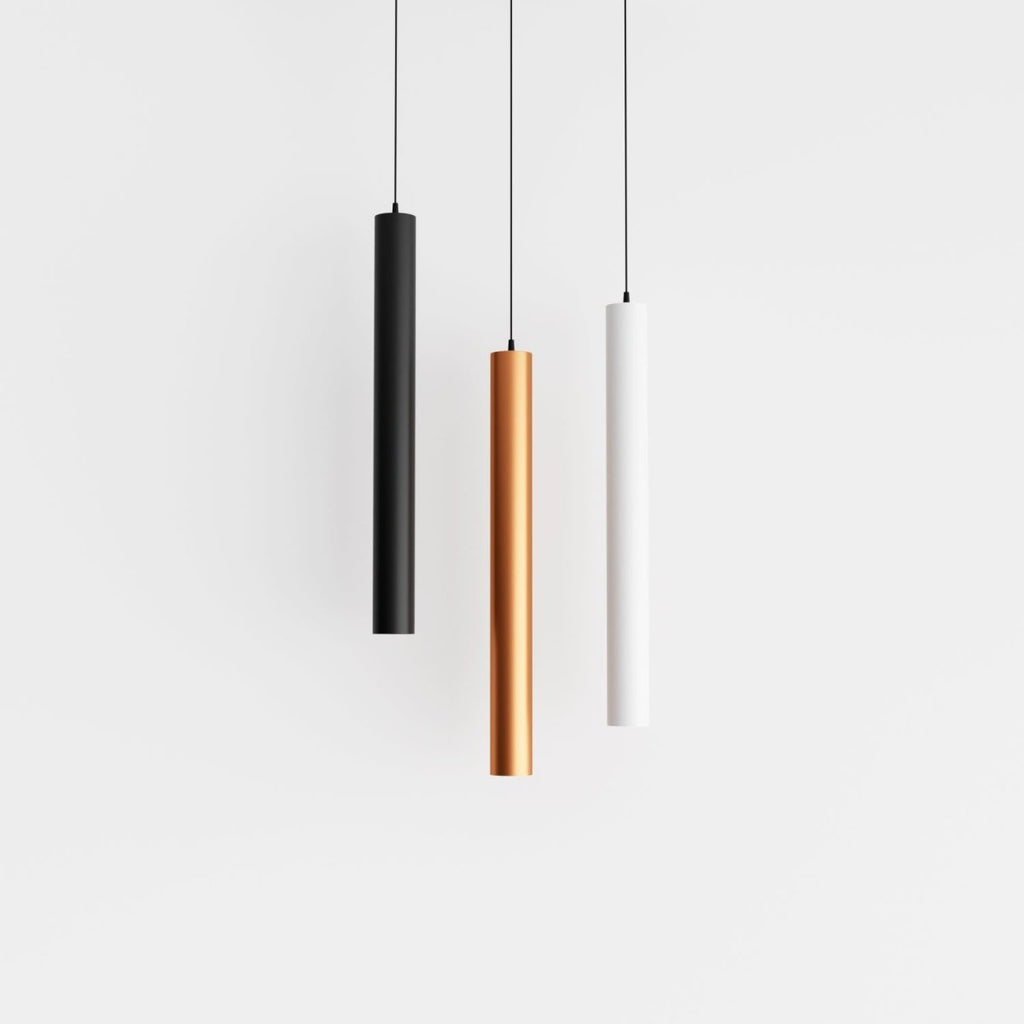 Clérachic cluster pendant light trio in black, gold and white cylinders suspended at matching heights on white.