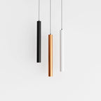 Clérachic cluster pendant light trio in black, gold and white cylinders suspended at matching heights on white.