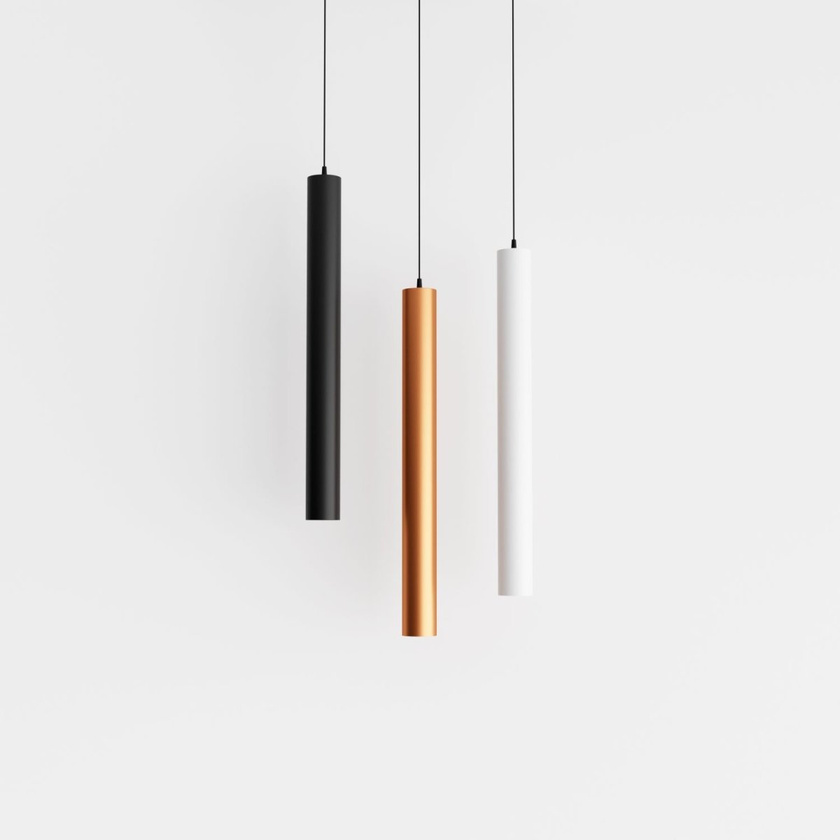 Clérachic cluster pendant light trio in black, gold and white cylinders suspended at matching heights on white.