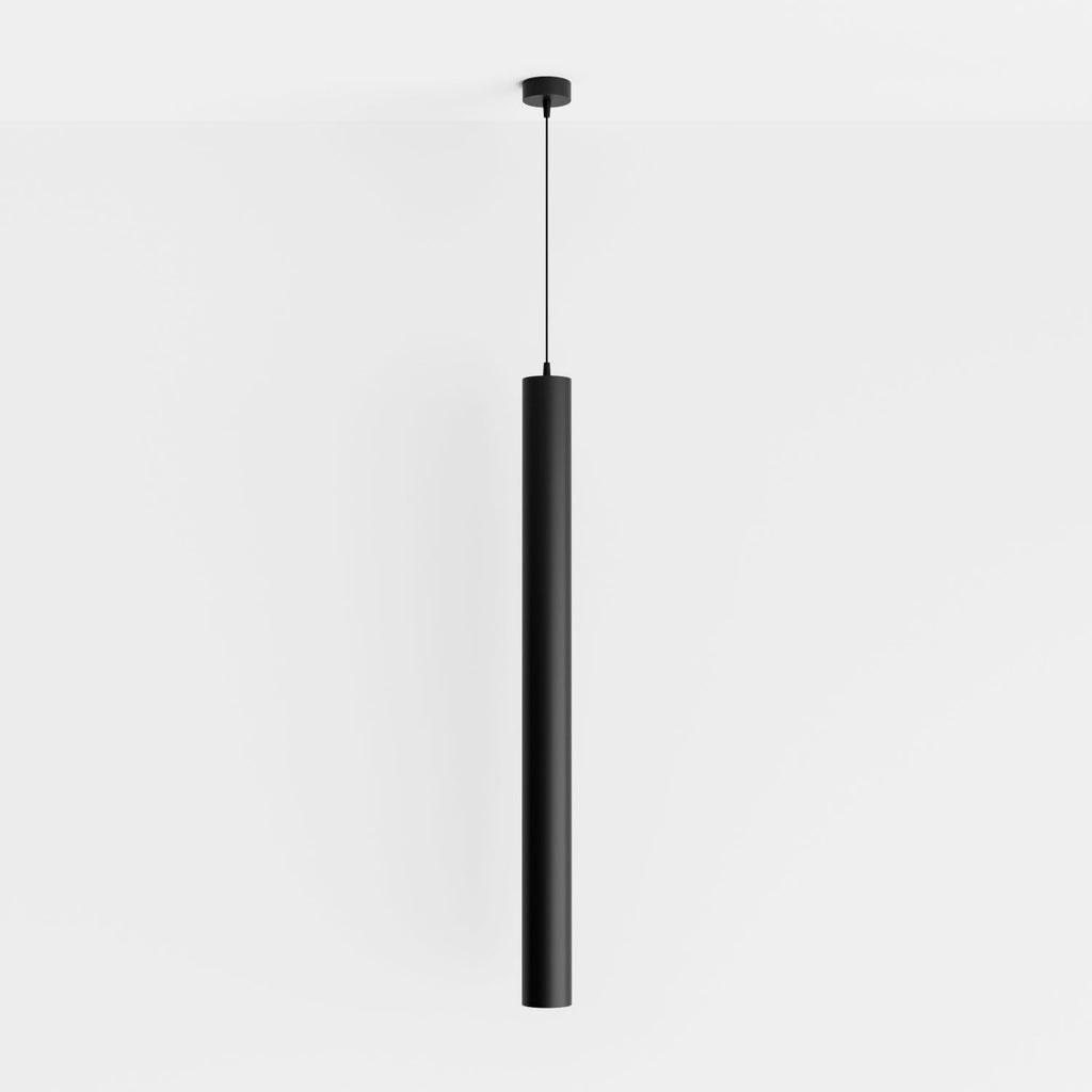 Clérachic cluster pendant light in matte black drops from a black ceiling canopy against a soft white studio wall.