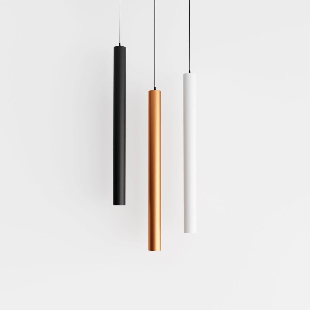 Clérachic cluster pendant light group in black, gold and white cylinders hanging evenly spaced on a white ground.