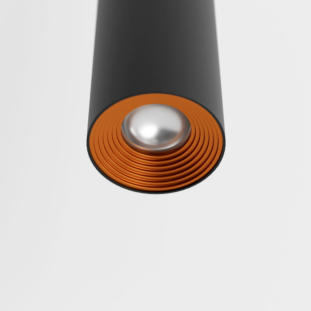 Clérachic cluster pendant light detail in matte black shows its copper-tone reflector ring and frosted lens beneath.