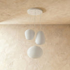 Clérachic three ribbed white glass pendants in egg, apple and wide oval shapes hanging from a white canopy, shown unlit.