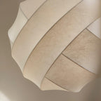 Clérachic globe pendant light in close-up, the crossing bands filling the frame and the fine web-like grain of the fibre visible across each one.