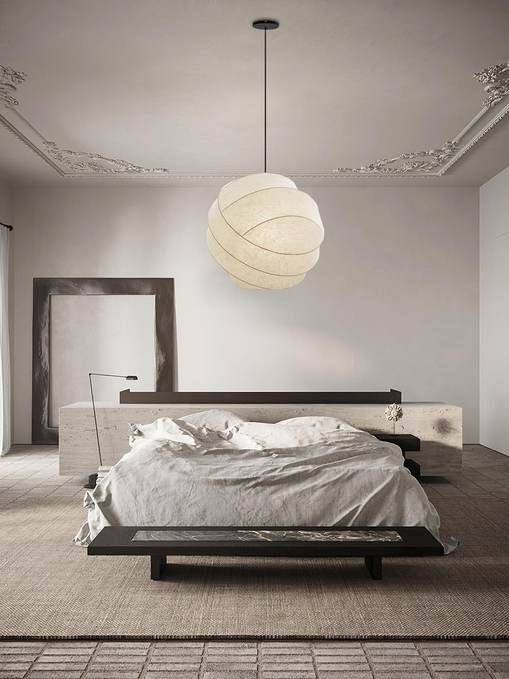 Clérachic globe pendant light hung from a black canopy in a room with ornate cornicing, above a low bed and a pale stone ledge on a woven rug.