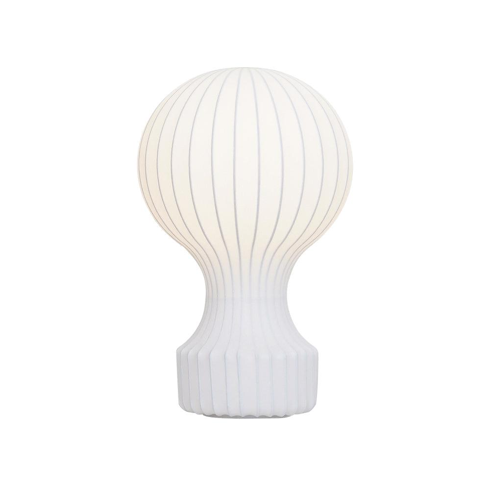 Front view of this Clérachic table lamp lit on a white background, its fine ribs showing through the white shade.