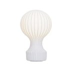 Front view of this Clérachic table lamp lit on a white background, its fine ribs showing through the white shade.