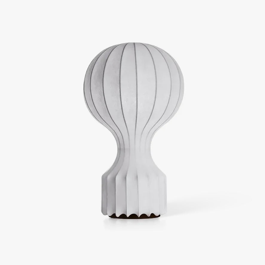 This Clérachic table lamp on a plain white backdrop, a pleated white shade swelling above a slim tapered stem and a ribbed base.