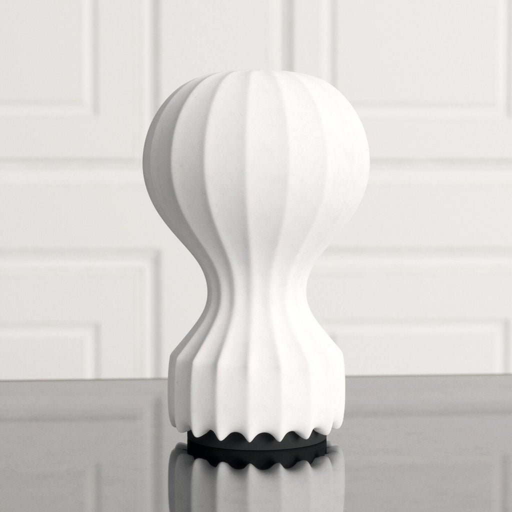 Close front view of a Clérachic table lamp, showing its ribbed white shade and the black scalloped base on a grey surface.