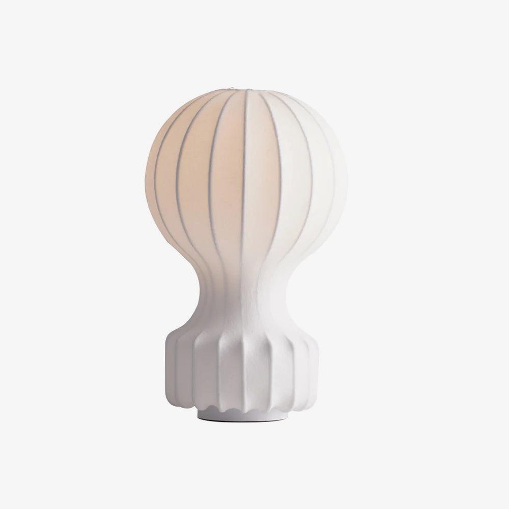 Clérachic table lamp lit from within on a pale backdrop, showing the vertical ribs of the shade and the ribbed white base.
