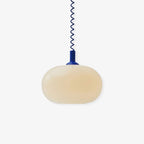 Blue-capped Clérachic pendant with a pale cream shade photographed on a white backdrop, with the coil cable running up.