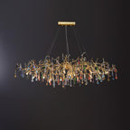 Clérachic multicolour raindrop chandelier, glass droplets hung along a gold branch frame on black.