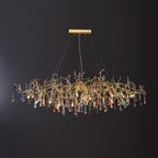 The Clérachic raindrop chandelier fuller on black, coloured glass drops massed under gold branches.