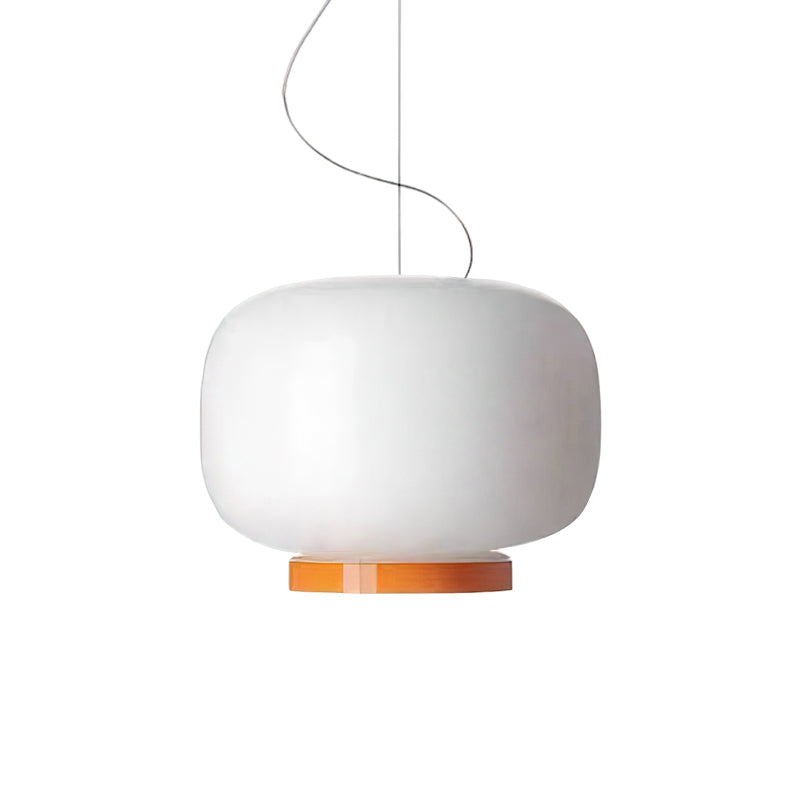 White glass lantern pendant with an orange band at its base, this Clérachic light on a plain white backdrop.