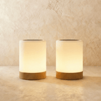A pair of Clérachic table lamps, two frosted cylinder shades on light wood bases glowing side by side.