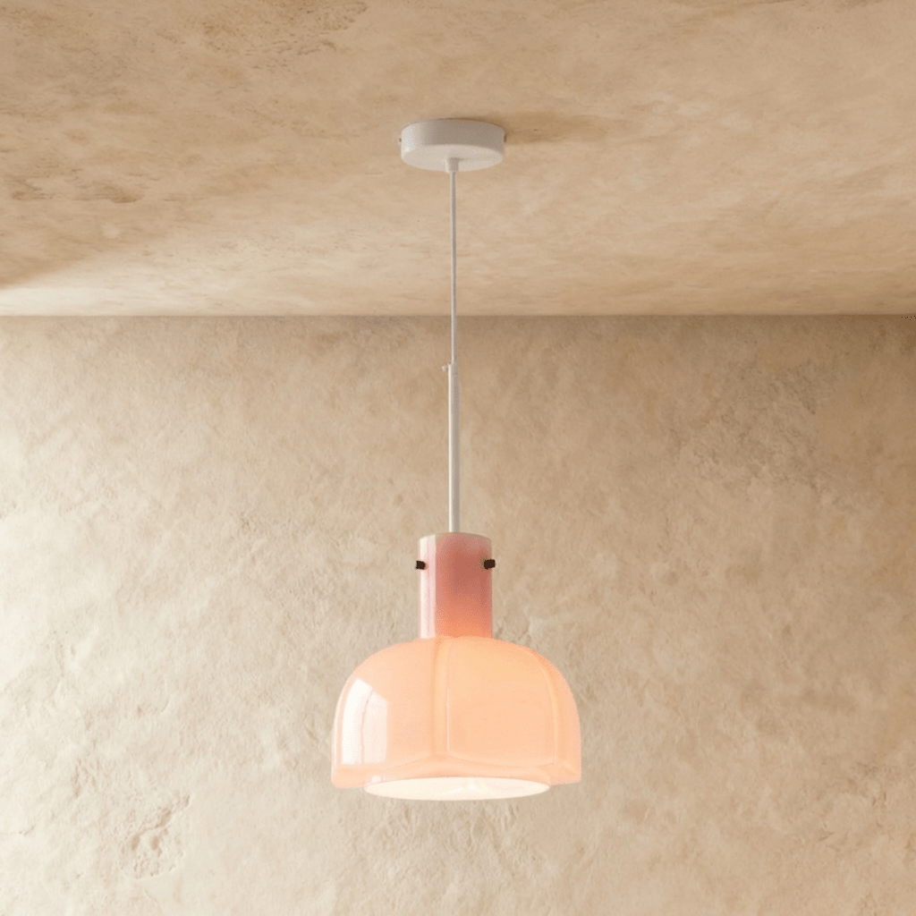 Clérachic soft pink glass pendant with a lobed shade lit from within, suspended from a white stem and ceiling canopy.