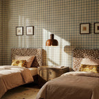Clérachic glossy brown glass pendant hanging between twin beds in a bedroom with gingham walls and striped bedding.