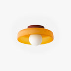 Clérachic coloured glass drum flush mount ceiling light in orange, shown against white with its terracotta canopy and opal globe.