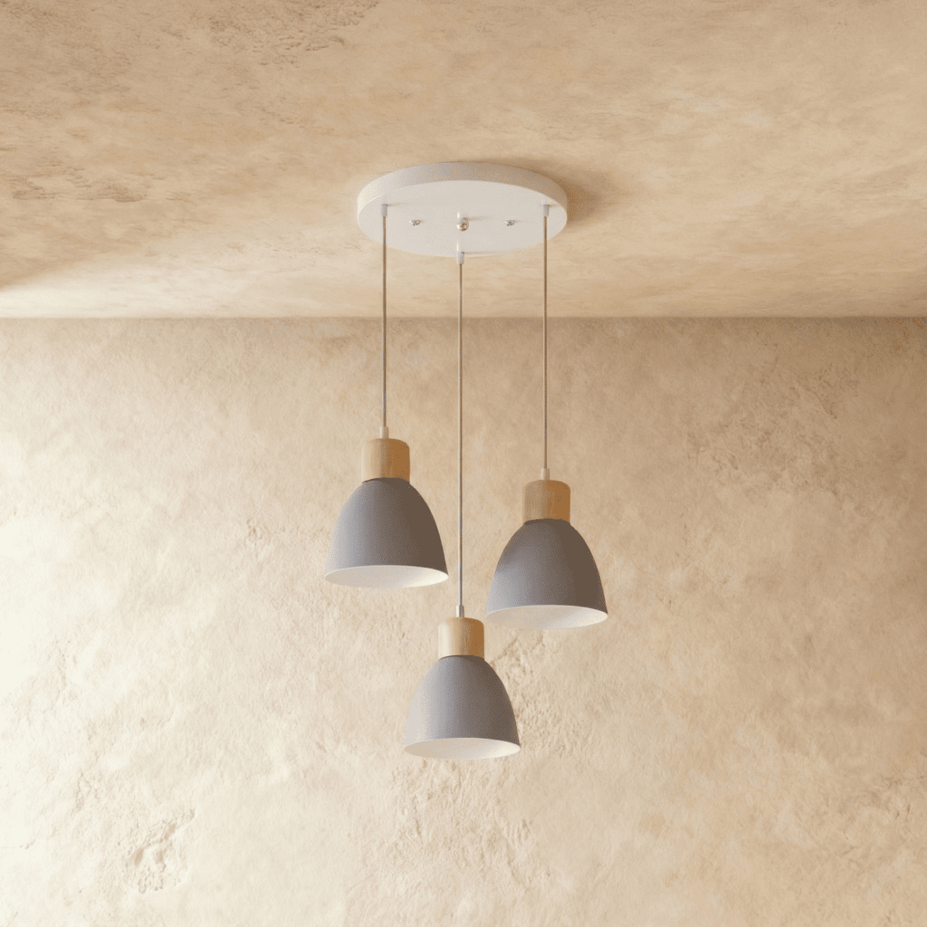 A Clérachic three-head wood disc pendant light in matte grey hangs from a round canopy against a warm plaster ceiling.