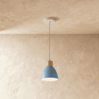 Side view of the Clérachic single-head blue wood disc pendant light with its wood collar and round metal shade.