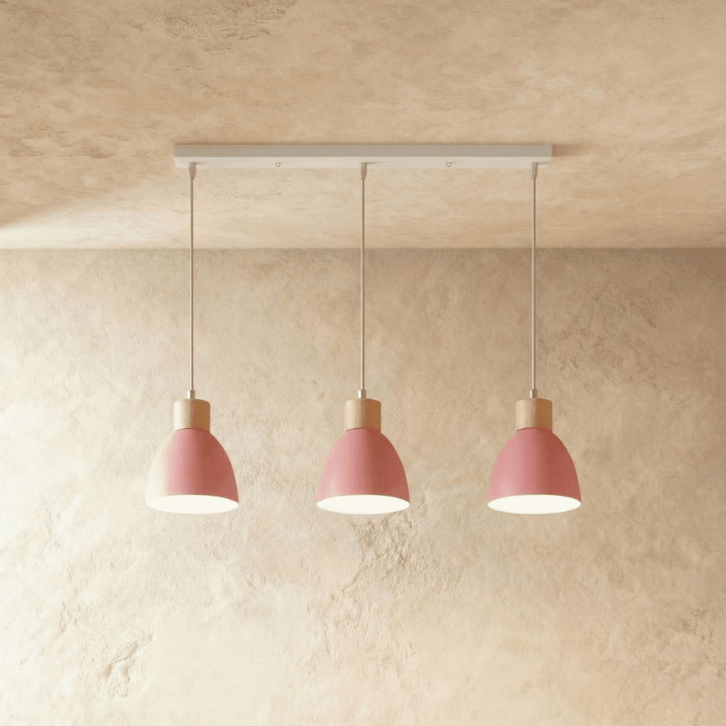 Closer view of the Clérachic three-head pink wood disc pendant light row on its slim linear ceiling bar.