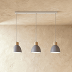 Closer view of the Clérachic three-head grey wood disc pendant light row on its slim linear ceiling bar.