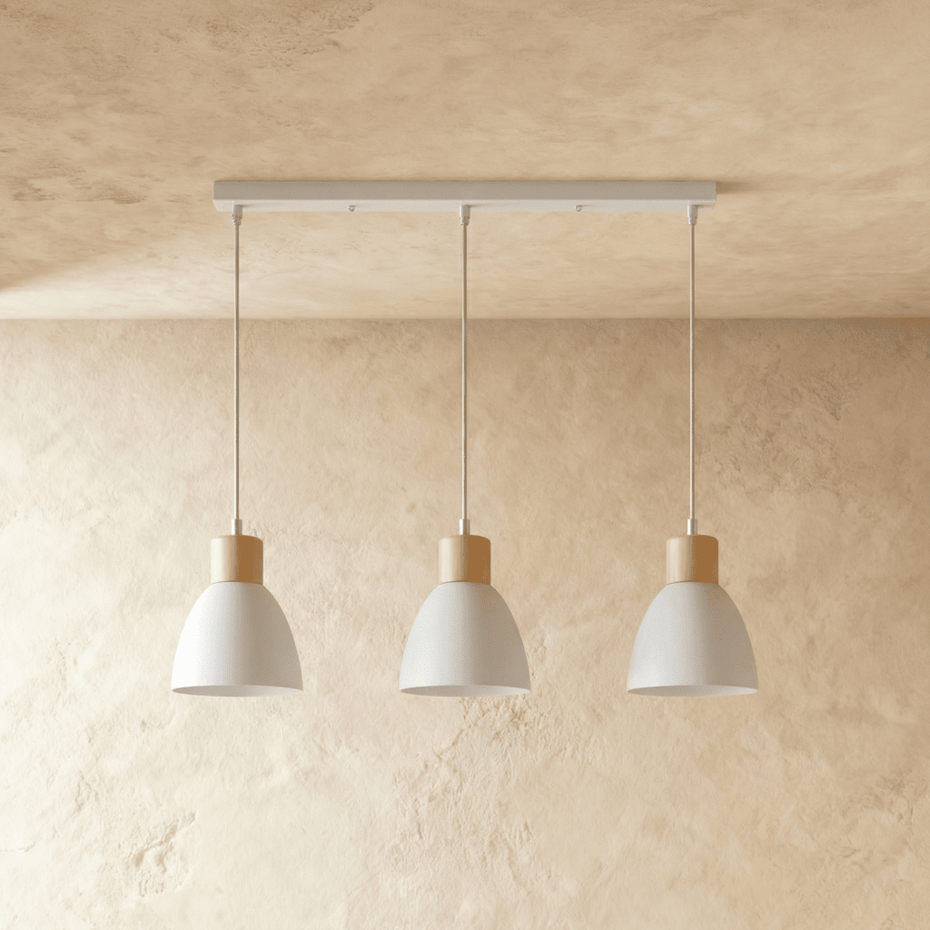 Three Clérachic wood disc pendant lights in warm white hang in a row from a linear bar over a plaster wall.