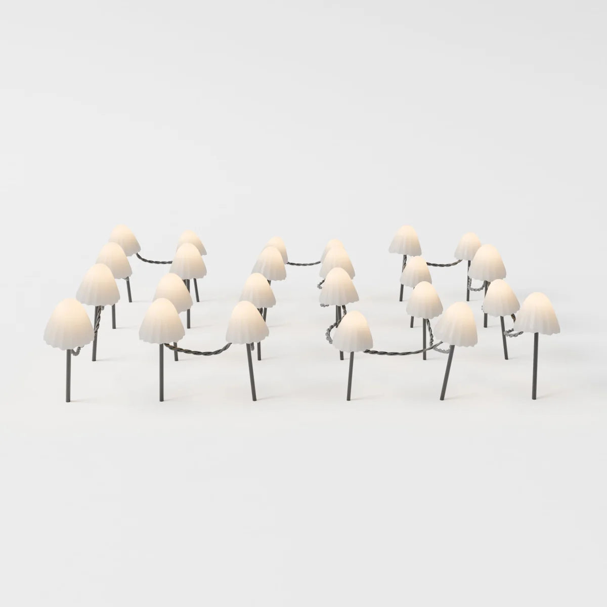 Clérachic solar mushroom stake lights, a cluster of cream glass mushroom caps on dark stems, linked by a woven cord, glowing warm white.