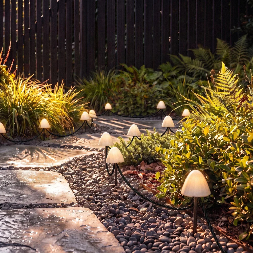 Sunlit view of Clérachic solar mushroom stake lights beside a gravel path, warm white glow visible under golden foliage.