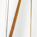 Close view of the woven ochre webbing on a Clérachic floor lamp strip, set against a bright white wall with a lit edge.