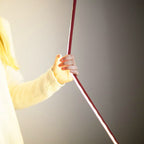 A hand holds the edge of a red Clérachic floor lamp strip, with a bright line of warm light along its side.