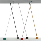 Wider render of this Clérachic floor lamp family, with strips crossing from a ceiling panel to bases in green, black, red and gold.