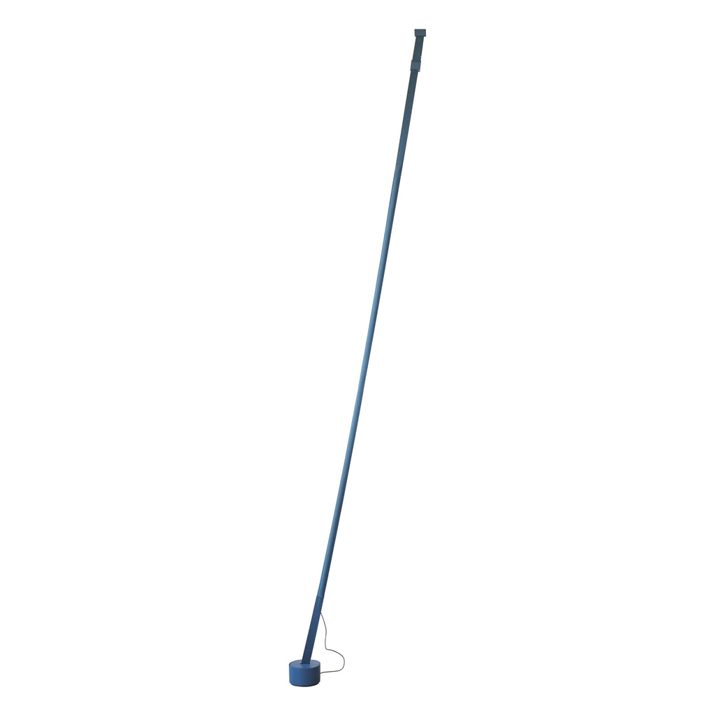 A slim grey-blue Clérachic floor lamp strip leans to a round blue base on a plain white backdrop, its cord trailing.