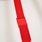Close view of a red metal sleeve joining the woven red webbing on a Clérachic floor lamp, with a hook-and-loop backing below.