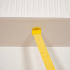 A small yellow metal plate and screw fix the top of this Clérachic floor lamp strip to the underside of a white ceiling beam.